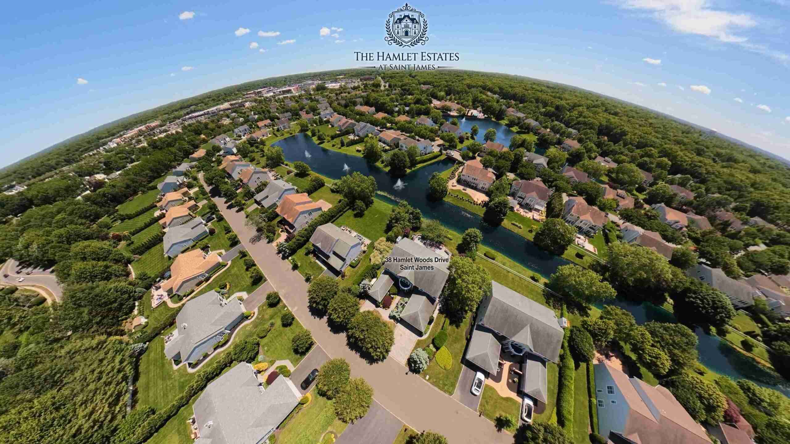 Little-planet 360 aerial of The Hamlet Estates at Saint James showing 38 Hamlet Woods Drive, the community lakes, and surrounding homes