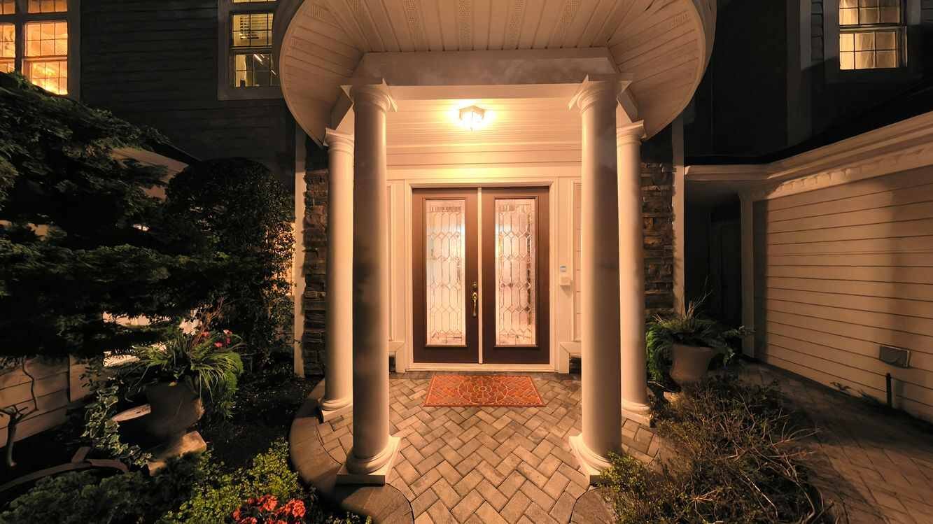 Illuminated double front entry doors at 38 Hamlet Woods Drive at dusk