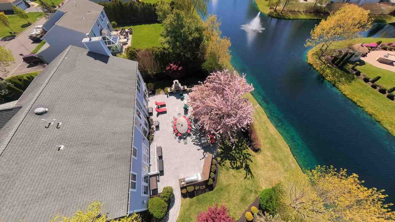 Aerial corner view of the property with a flowering cherry tree on the grounds