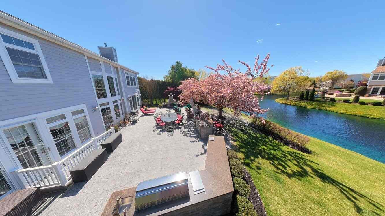 Ground-level corner view of the property and flowering cherry tree