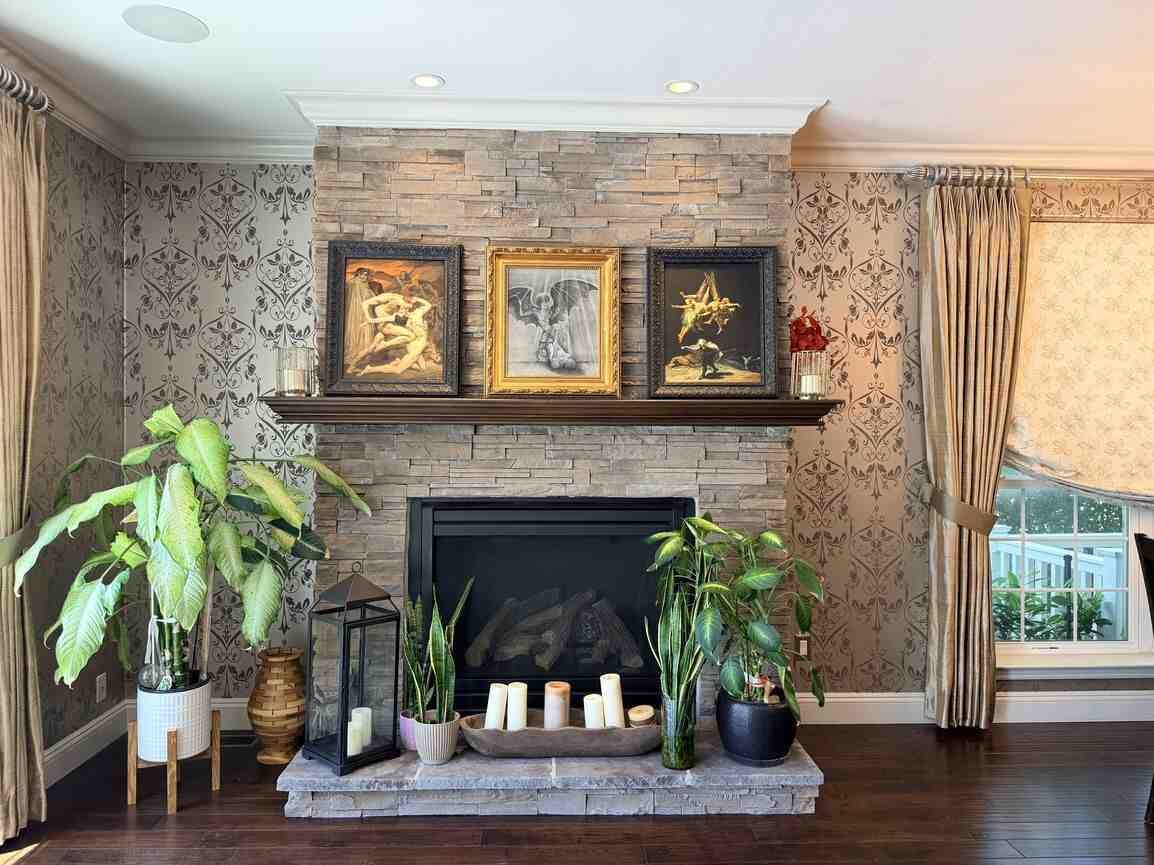 Living room with floor-to-mantel stacked-stone gas fireplace, hardwood floors, and patterned drapery